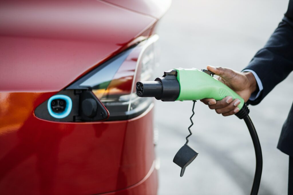 Close up of male hand holding green electric charging plug